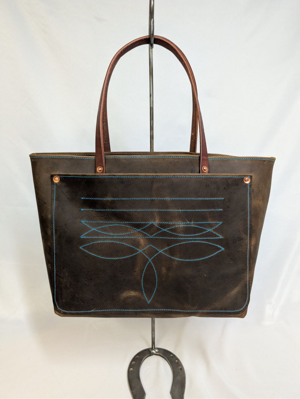 Dark brown leather tote with turquoise stitching