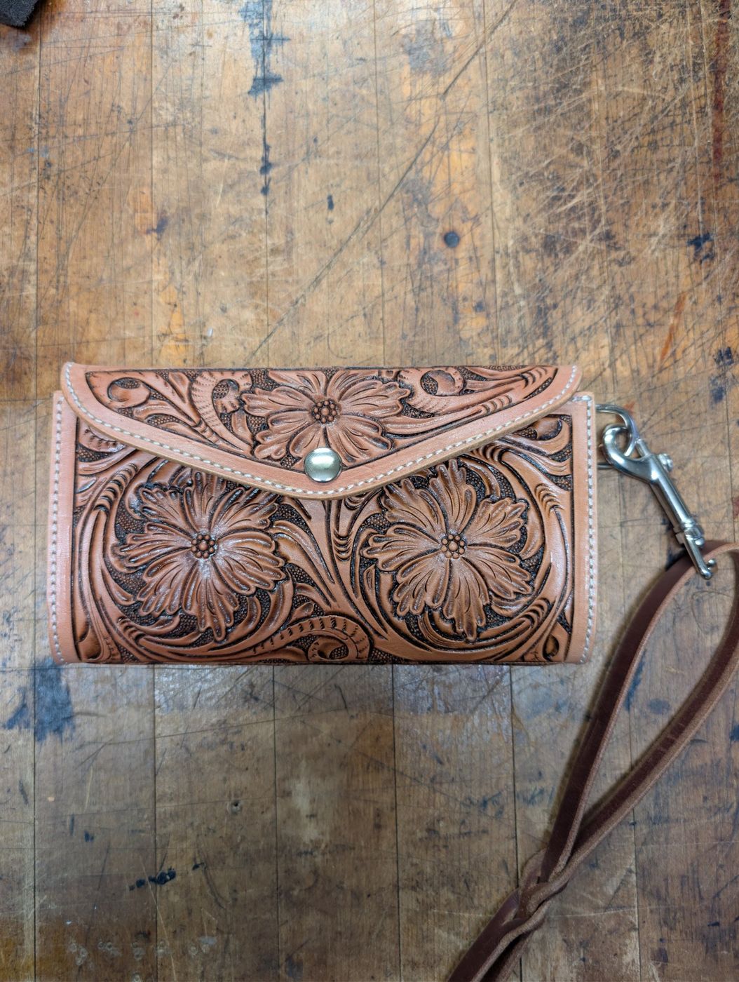 Floral carved leather clutch with wrist strap